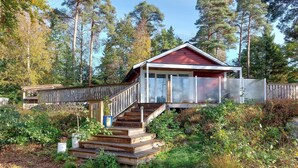 A cabin with a wooden staircase leading to a red-roofed structure, surrounded by dense forest. - 3 bedroom awesome home in örkelljunga (Örkelljunga)