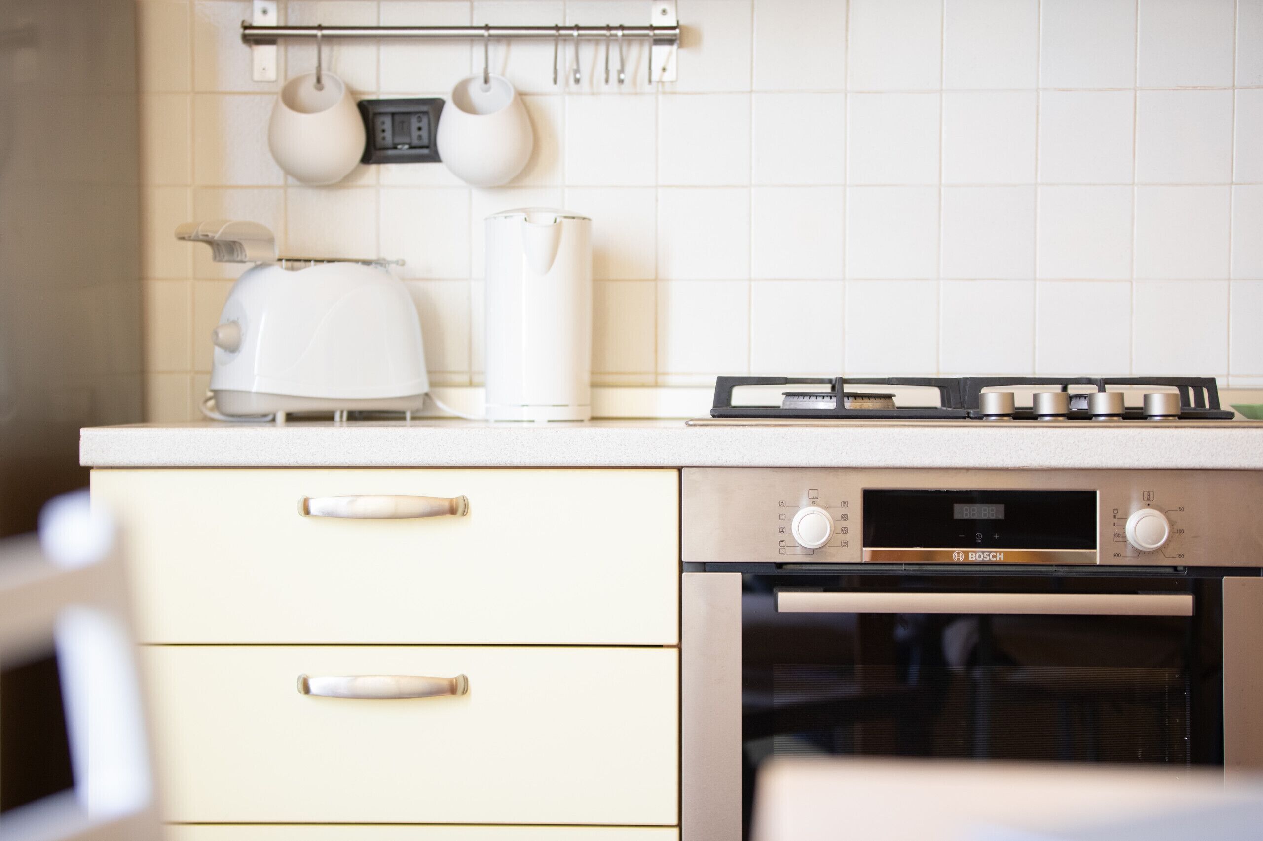 Eine Küche mit einem Backofen von Bosch, einem Wasserkocher und einem Toaster auf der Arbeitsfläche.