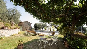 A patio with a pool, outdoor furniture, and potted plants. - Villa Iris with Swimming Pool (Capannori)