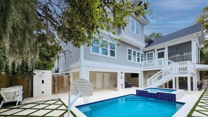 A two-story house with a swimming pool, a basketball hoop, and a covered patio area. - 40 N. Forest Beach-New Owners & Vrbo listing - 176 Yard walk to the beach. (Hilton Head Island)