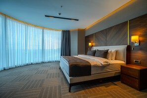 A modern hotel room with a large bed, a nightstand, a wall-mounted lamp, and a ceiling fan. - B'İstanbul Hotel (Istanbul)