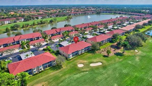 A residential area with multiple buildings, a lake, and a golf course. - Cypress Woods for Seasonal or Summer Stays W Golf (Naples)