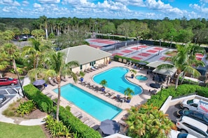 Un hôtel doté d’une piscine, de chaises longues et de palmiers.