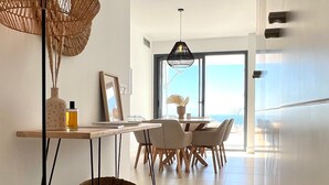 Una cocina moderna con zona de comedor, con un amplio ventanal y vistas, una lámpara colgante y una lámpara de pie.