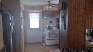 A kitchen with a refrigerator, stove, and wooden cabinets. - Private 3-bedroom ranch, 10 miles from Bethany Beach, on a dead-end street. (Dagsboro)