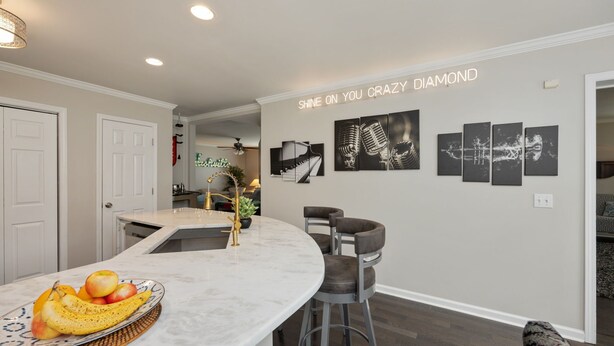 A modern kitchen with a marble countertop, a fruit bowl, and a wall with framed artwork. - Beautiful home in great location close to downtown, Nashville Heights (Nashville)