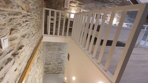 A staircase with a stone wall on one side and a white railing. - Cozy Loft in Chora of Andros 1 min from the main beach! (Andros)