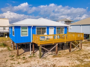 A blue house with a wooden deck, white windows, and a white door. - Boa Vista - 106 Ponchartrain 3 Bedroom Home by RedAwning (Dauphin Island)