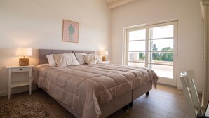 A bedroom with a large bed, two bedside tables with lamps, a framed picture on the wall, and a large window offering a view of greenery outside. - Villa Stella Smoljanci (Svetvincenat)