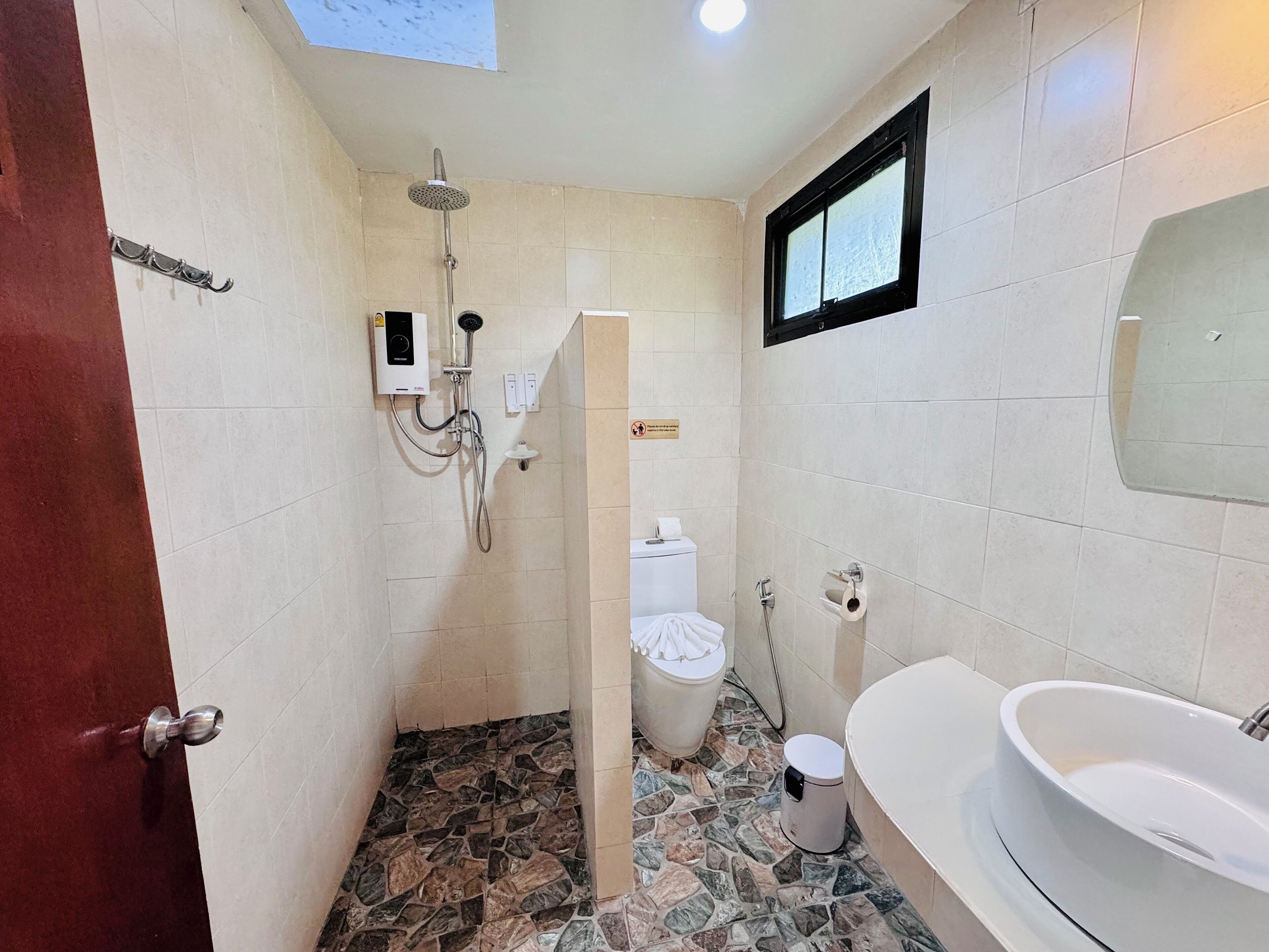 A bathroom with a shower, toilet, and sink.