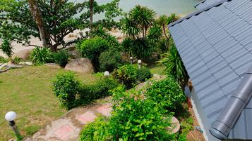 A garden with a variety of plants and a view of a body of water.