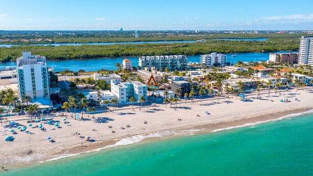 An aerial view of a coastal resort with beachfront villas, palm trees, and a clear view of the ocean. - 3/3 Duplex for 6+Shared Heated Pool, Tiki Bar BBQ (Hollywood)