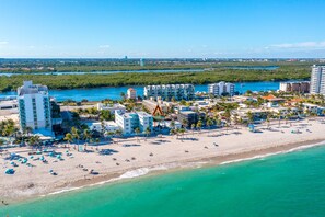 An aerial view of a coastal resort with beachfront villas, palm trees, and a clear view of the ocean. - 3/3 Duplex for 6+Shared Heated Pool, Tiki Bar BBQ (Hollywood)