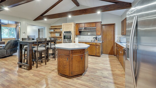 A spacious kitchen with wooden cabinets, a central island, and stainless steel appliances.