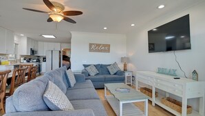 A modern living room with a grey sofa, a coffee table, and a TV mounted on the wall. - Oceanfront Murrells Inlet Home w/ Beach Access! (Murrells Inlet)
