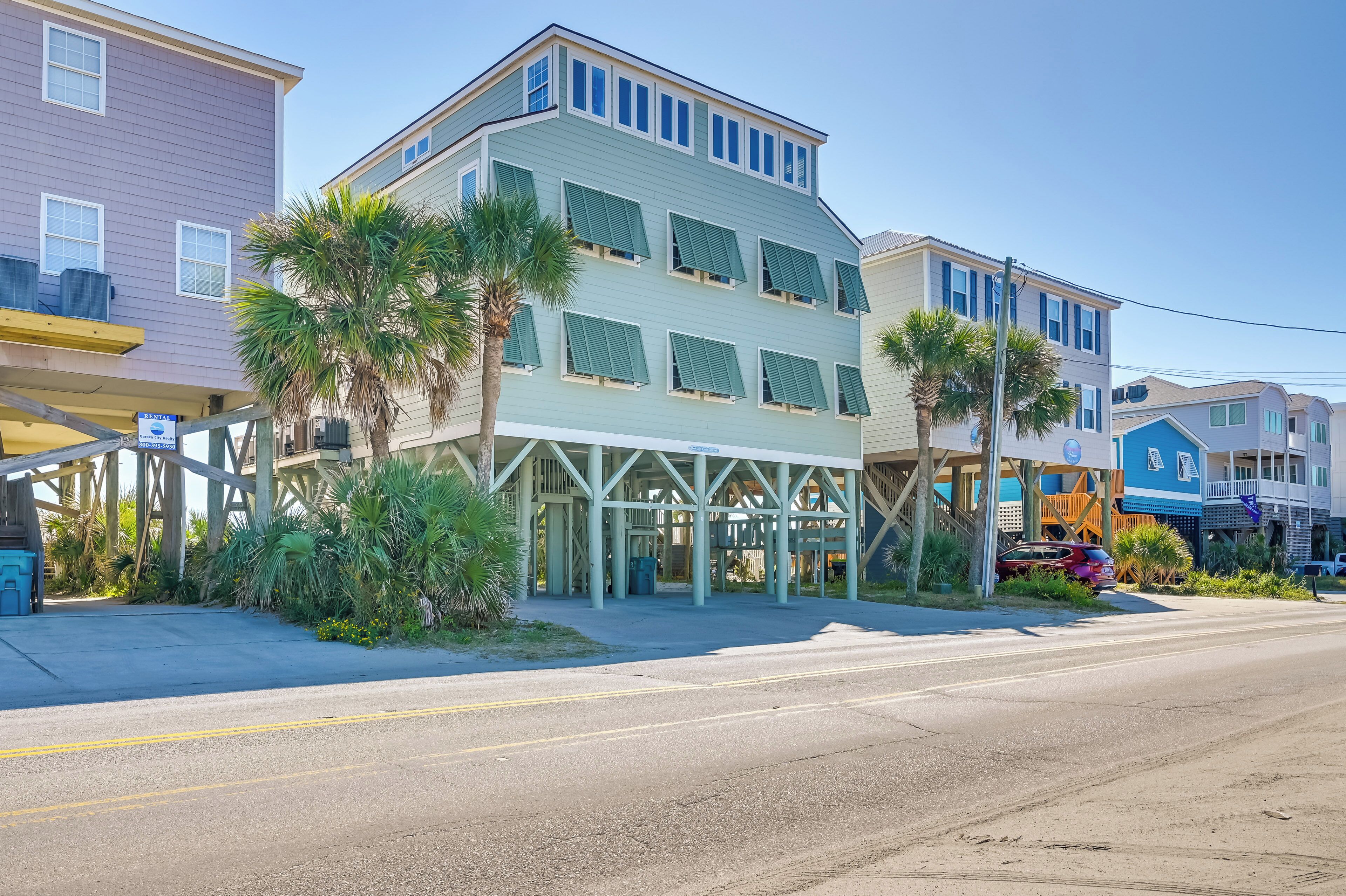 A multi-story hotel with a covered entrance and palm trees.