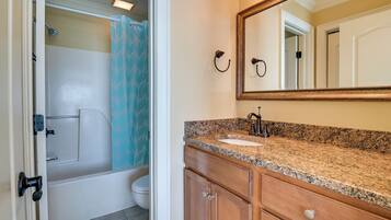 A bathroom with a bathtub, toilet, and sink.