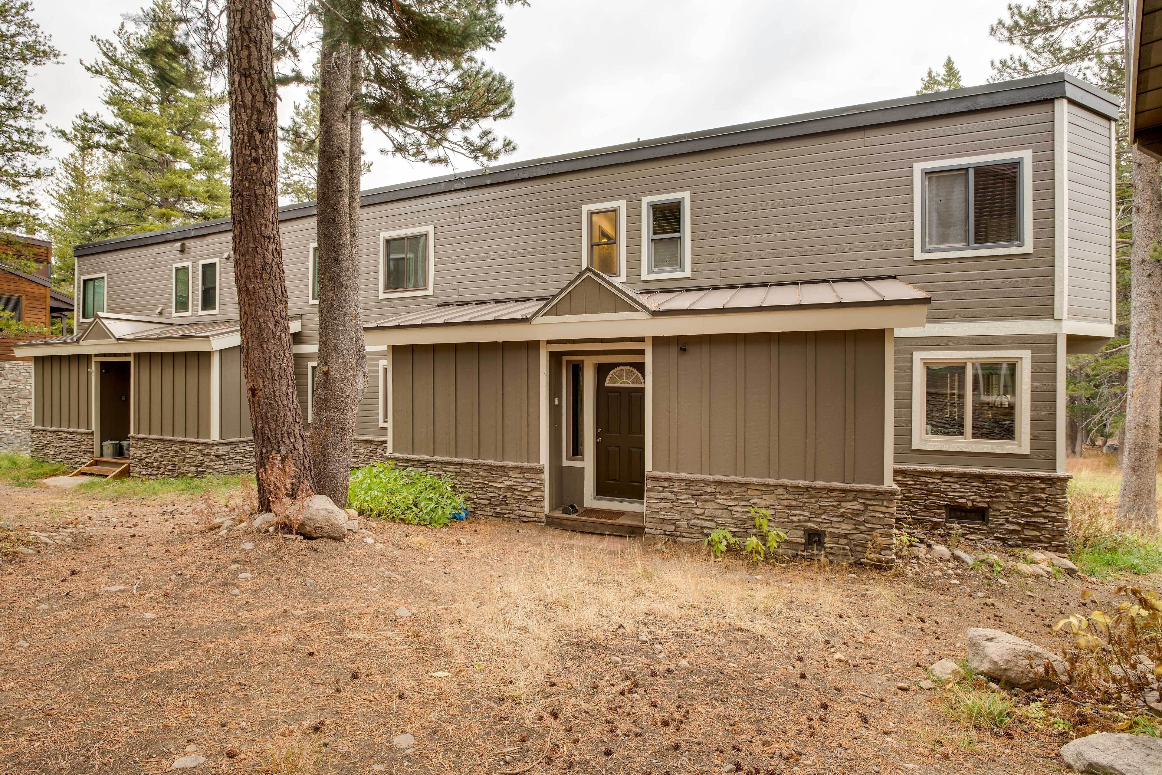 A two-story building with a stone foundation and a brown exterior.