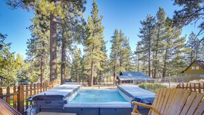 A hot tub surrounded by wooden chairs and a wooden deck, with tall pine trees in the background. - 1 Mi to Lake: Home w/ Hot Tub & Gazebo in Big Bear (Big Bear Lake)