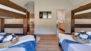 Une chambre avec deux lits superposés, chacun étant équipé d’un panier contenant des serviettes et une couverture.