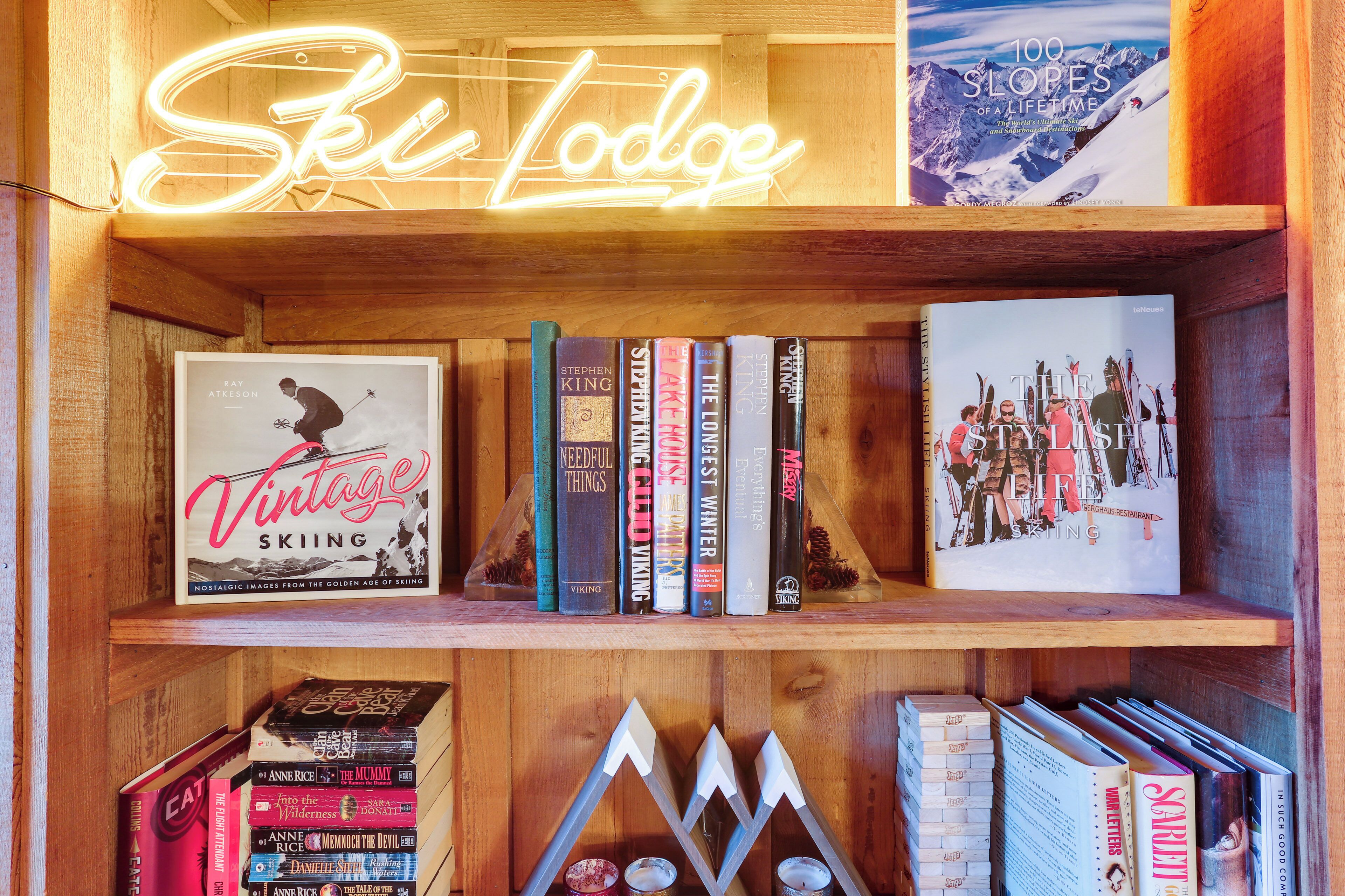 Una estantería de madera con libros y un letrero de neón que dice "Ski Lodge".