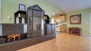 A modern kitchen with dark cabinetry, a microwave, and a wooden cabinet.