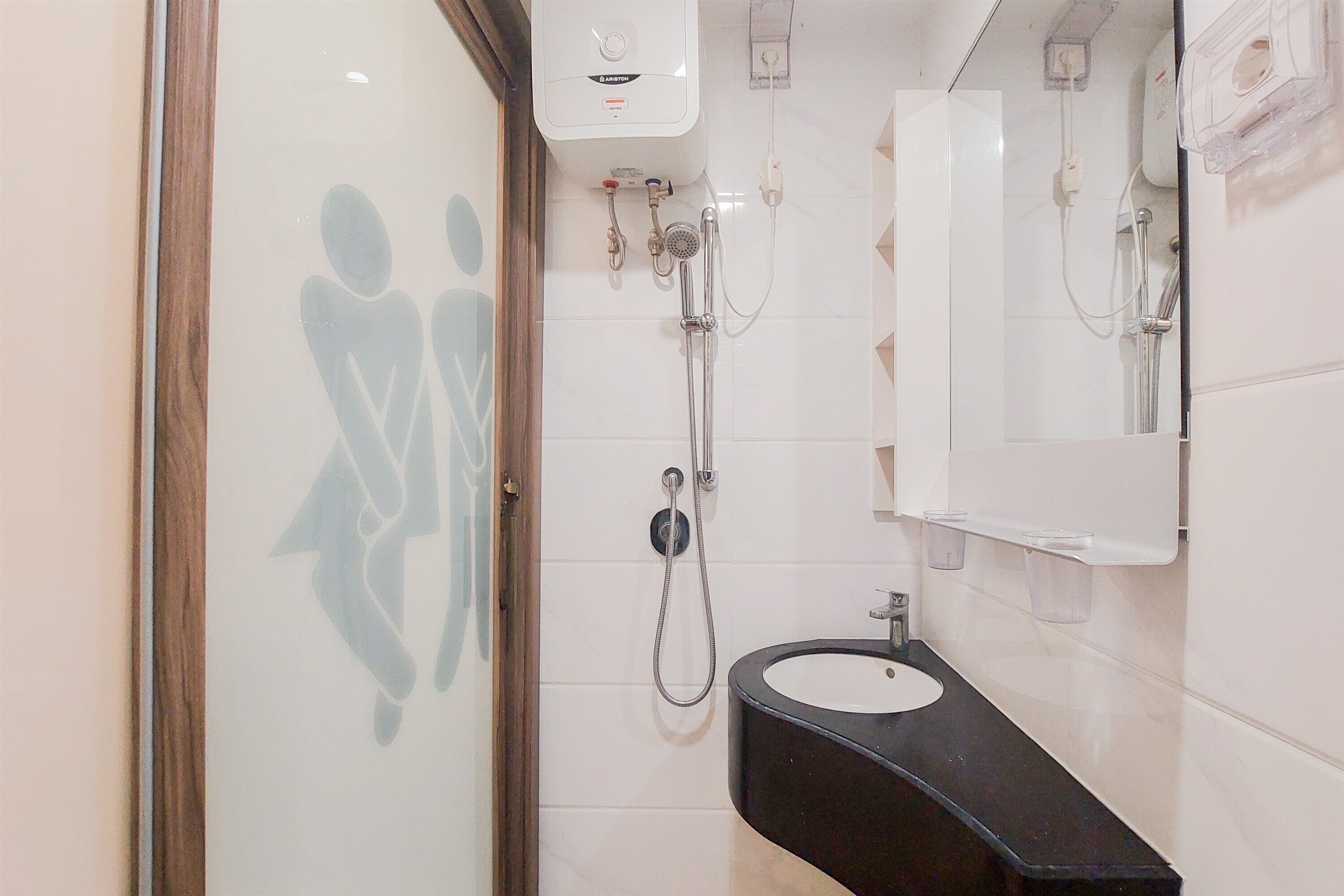 Une salle de bain comprenant des toilettes, un lavabo, un miroir et une douche.