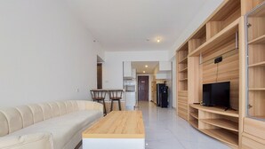 Ein modernes Wohnzimmer mit einer Couch, einem Couchtisch und einer eingebauten Holzregalanlage mit Fernseher.