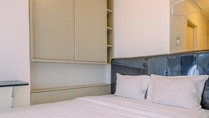 Ein Hotelzimmer mit einem Bett, einem Holzschrank und einem Nachttisch.