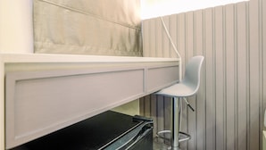 A compact room with a bed, a small desk, and a chair. - Modern And Comfy Studio At Tokyo Riverside Pik 2 Apartment (Teluknaga)