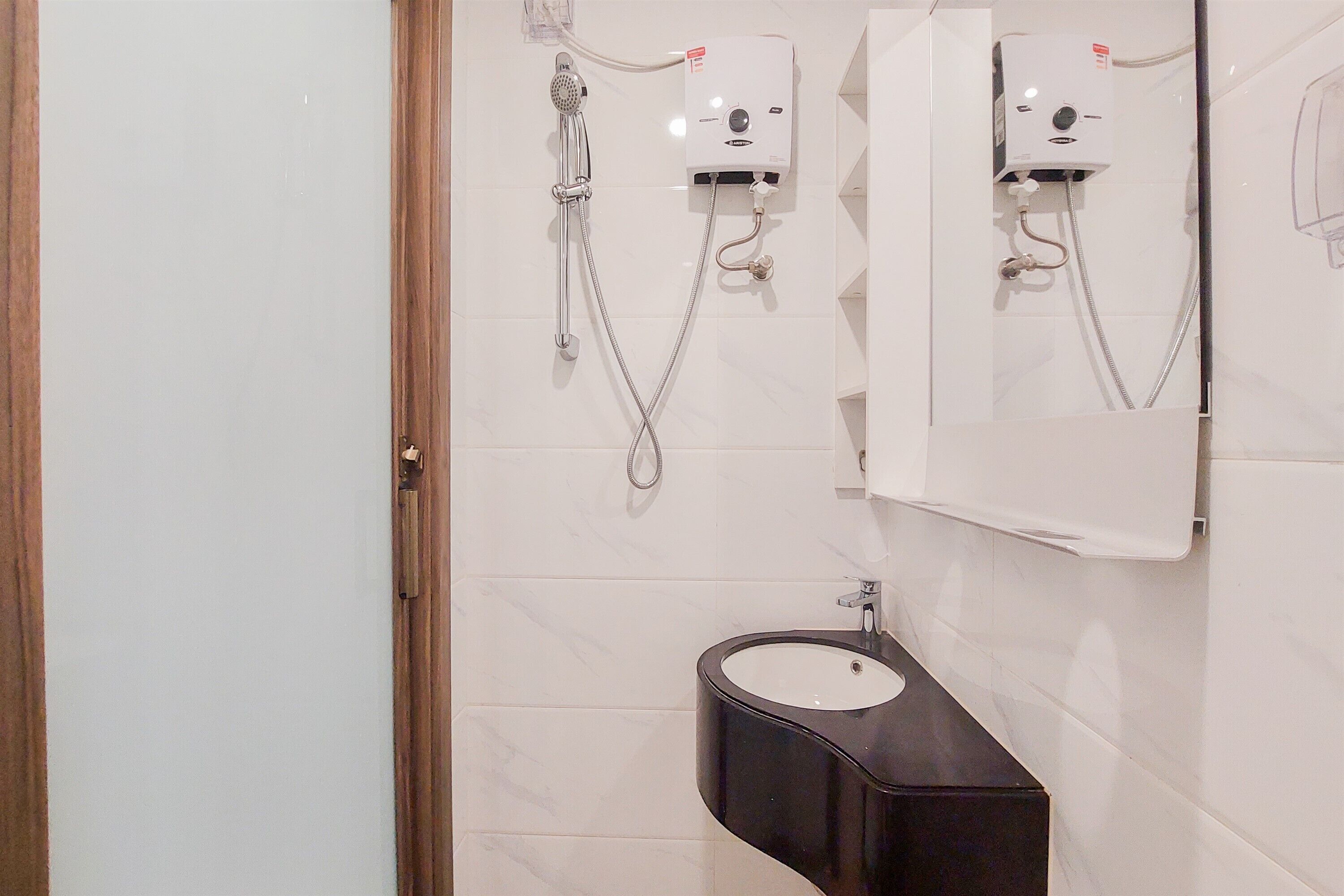 A bathroom with a toilet, a sink, and a shower unit.
