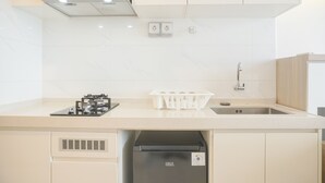 Una cocina moderna con estufa a gas, lavavajillas integrado y extractor de acero inoxidable.
