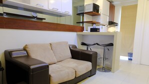 A modern kitchen with a built-in stove, a coffee machine, and a small bar area.