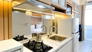 A compact kitchen with a stove, sink, and cabinets.