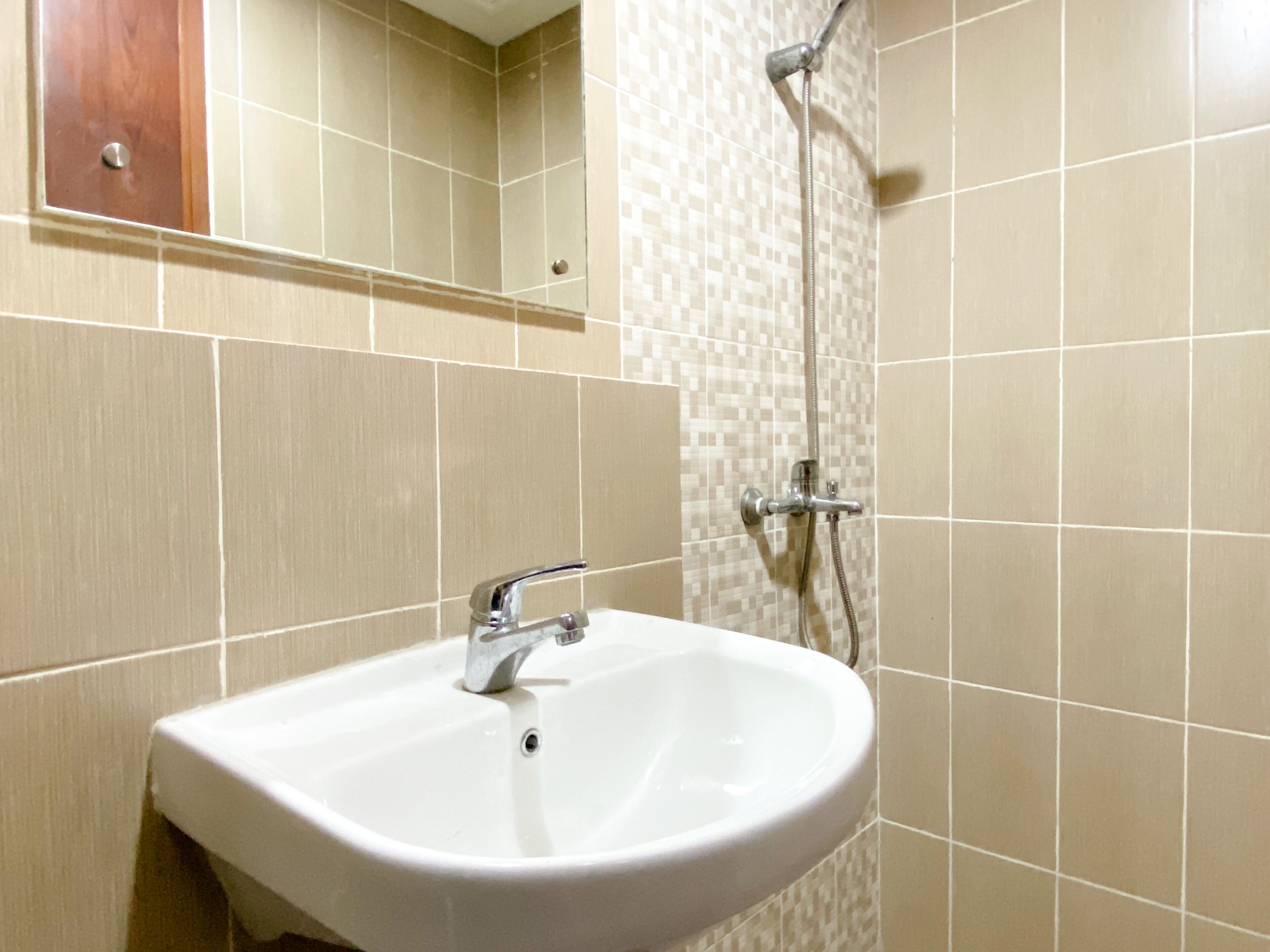 Une salle de bain avec un lavabo blanc, un miroir et une douche.