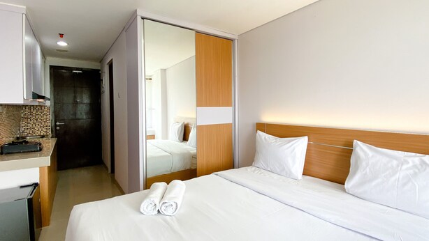 Hotellihuone, jossa on sänky, työpöytä ja kylpyhuone.