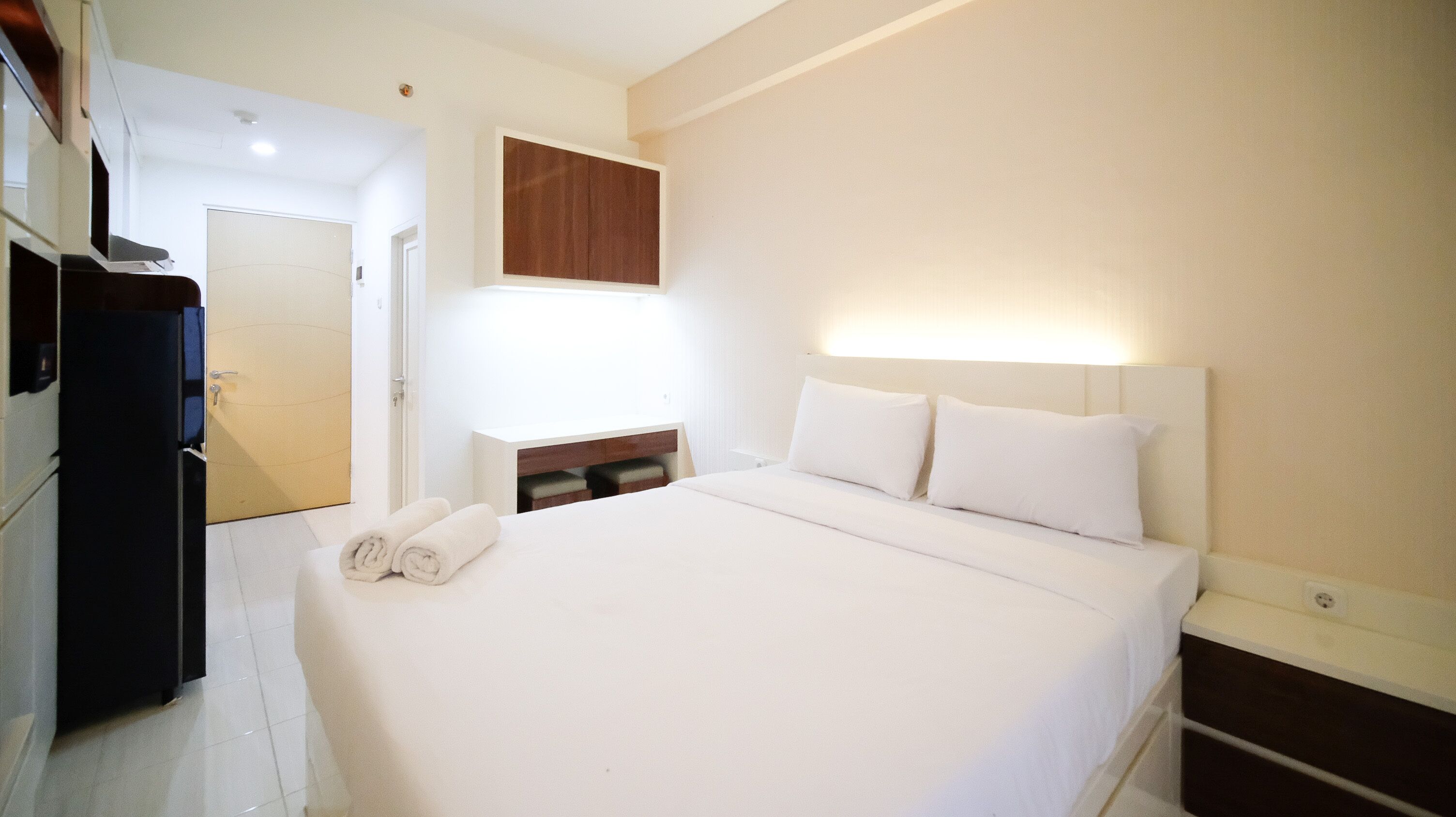 Ein Hotelzimmer mit Bett, Schreibtisch, Stuhl und Kleiderschrank.