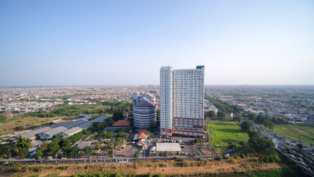 A high-rise building with a modern design, surrounded by a mix of residential and commercial buildings. - Tidy And Comfy Studio At Bale Hinggil Apartment (Surabaya)