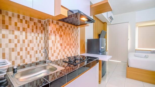 Uma cozinha moderna com fogão a gás, pia e painel de madeira.