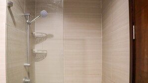 A shower with a handheld showerhead and a wall-mounted faucet. - Nice And Homey Studio At West Vista Apartment (Jakarta)