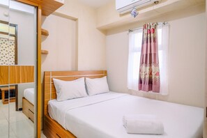 Relax in a serene space with a neatly made bed, wooden headboard, and large mirror.