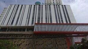 Ein Gebäude mit modernem Design, das vertikale Streifen und ein markantes Logo oben aufweist.