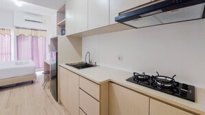 Una cocina compacta con estufa a gas, un lavamanos y un refrigerador.