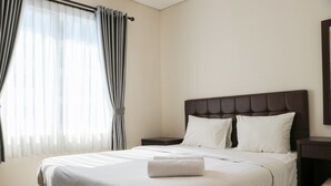 A neatly made bed with white linens, a headboard, and two bedside tables with lamps. - Full Furnished With Comfort Design 2Br Apartment At Thamrin Residence (Jakarta)
