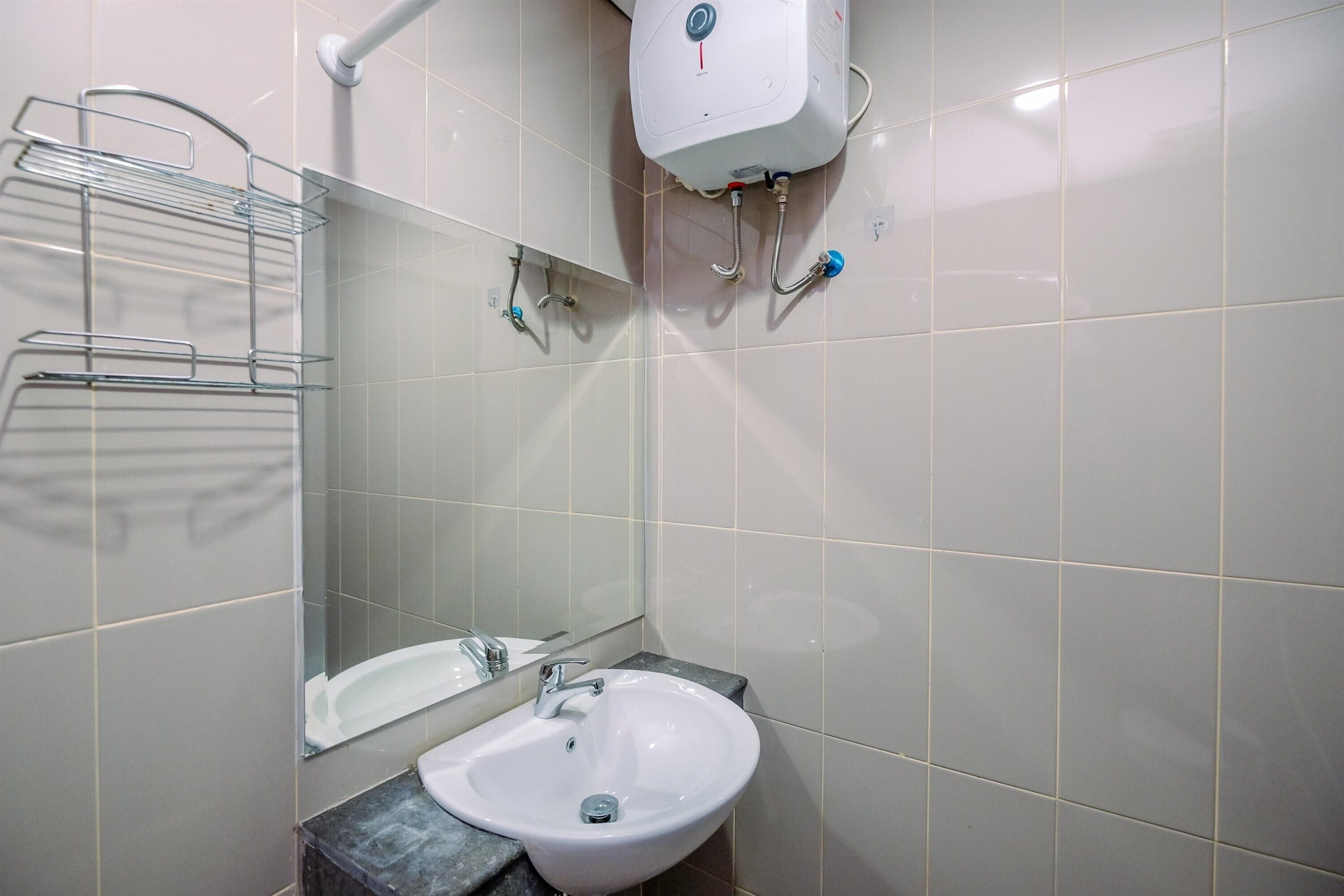 A bathroom with a white sink, a mirror, and a towel rack.