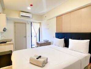 Relax in comfort with a large bed, bedside table, and air conditioning unit.