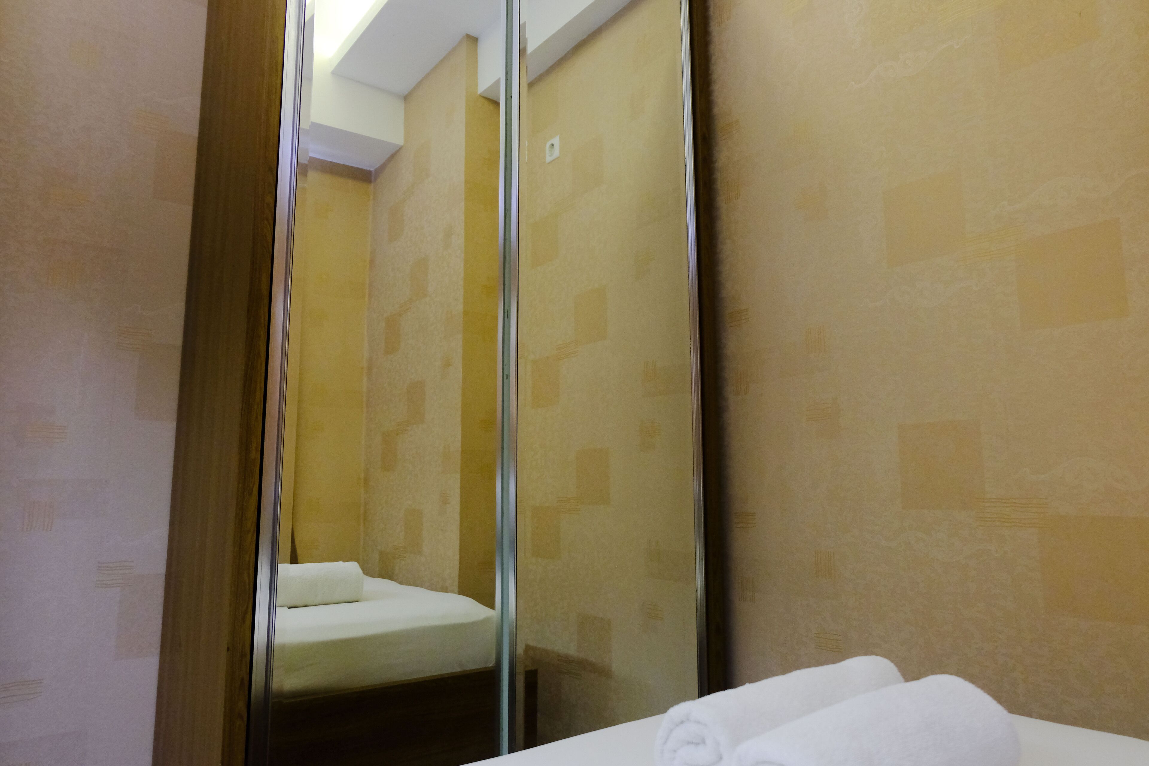Un baño de hotel con un espejo grande, un lavamanos blanco y una toalla en el suelo.