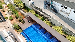 An aerial view of a residential area with a swimming pool, outdoor furniture, and greenery. - Homey And Compact Studio At Azalea Suites Apartment (Cikarang)