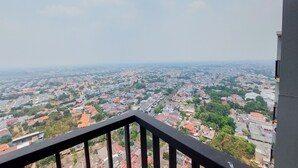 A balcony with a view of a densely populated urban area. - Homey Living Studio Tamansari Bintaro Mansion Apartment (South Tangerang)