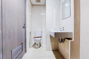 Bathroom features a toilet, sink, and shower with a wall-mounted control panel.